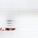Person peeking through curtains